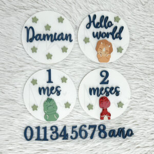Decorative white round name plaques with blue cursive text, green stars, and small dinosaur illustrations on a fluffy white background.